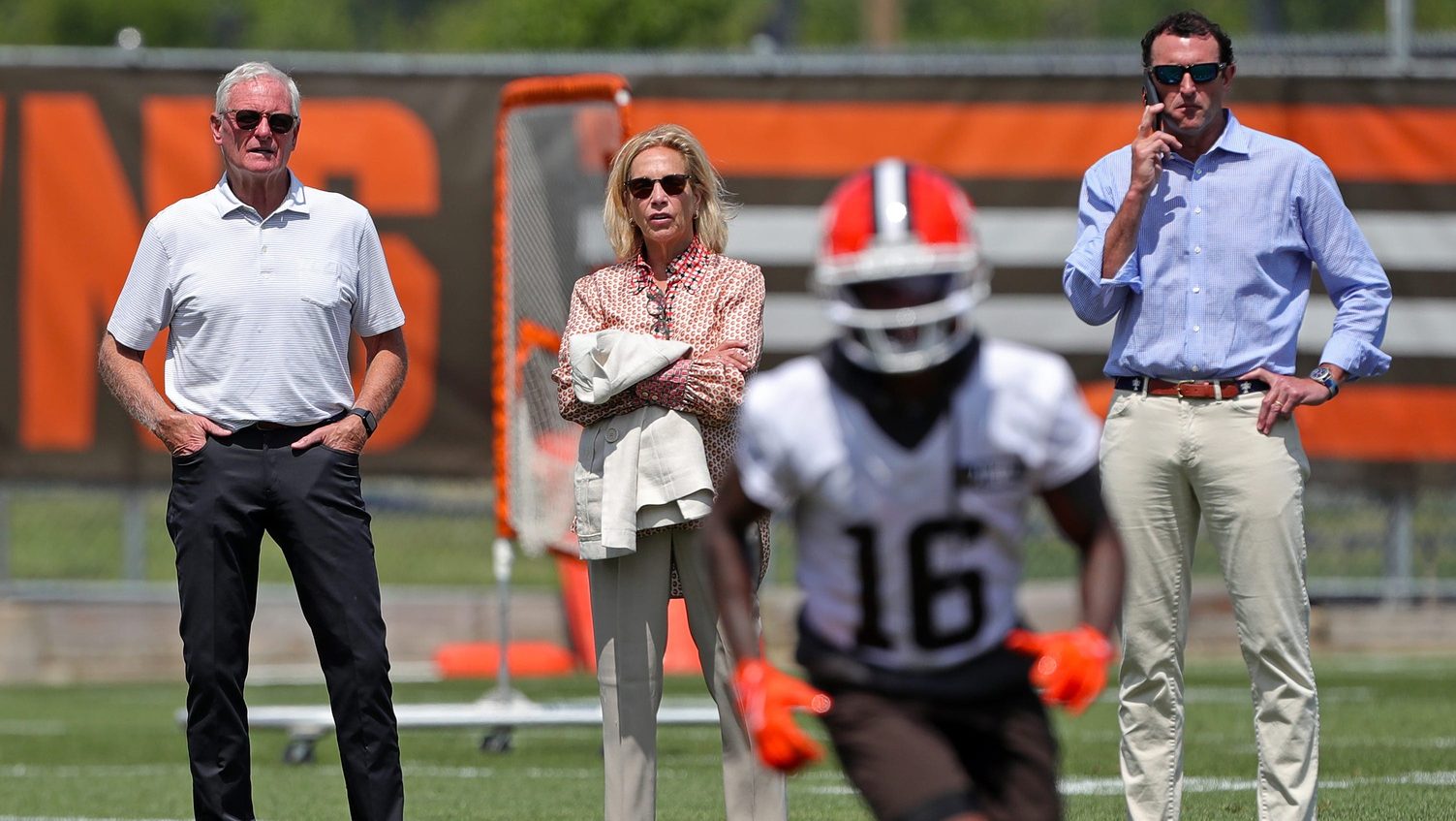 Browns owners Jimmy and Dee Haslam, left and center, watch practice with executive vice president J.W. Johnson, right, during minicamp, Thursday, June 13, 2024, in Berea.