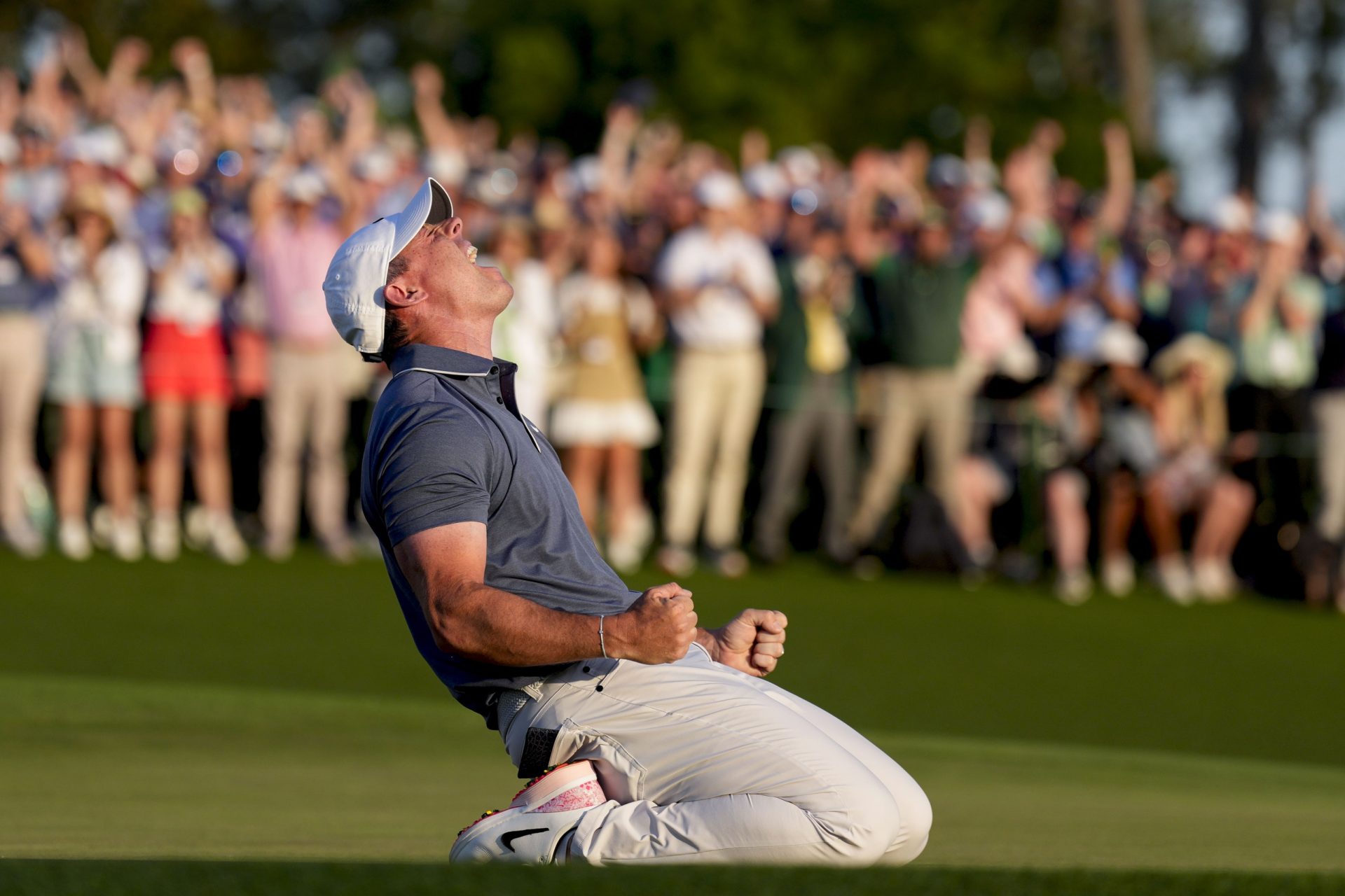 Apr 13, 2025; Augusta, Georgia, USA; Rory McIlroy falls to his knees in celebration after winning a playoff on the no. 18 green during the final round of the Masters Tournament at Augusta National Golf Club.
