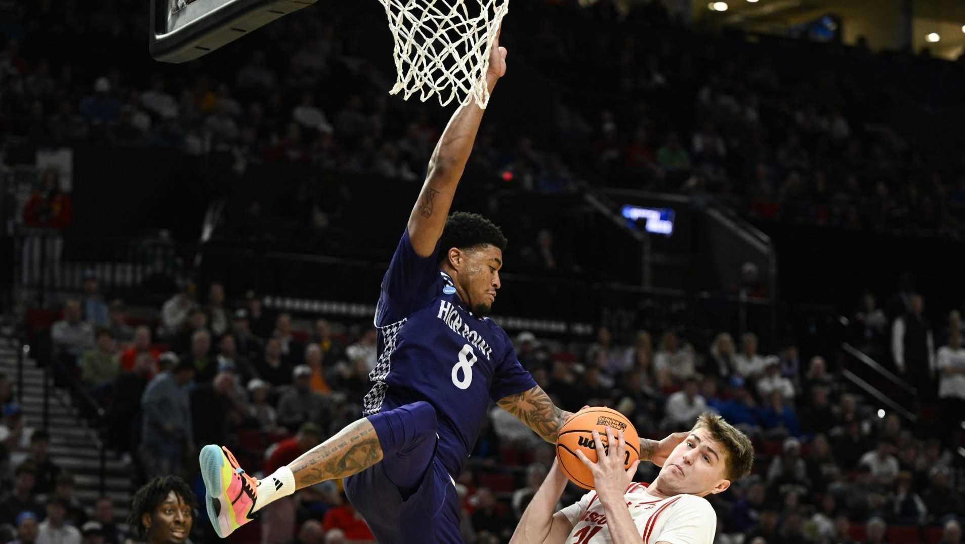 Mar 19, 2026; Portland, OR, USA; High Point Panthers forward Owen Aquino (8) defends abasing Wisconsin Badgers forward Nolan Winter (31) during the second half of a first round game of the men's 2026 NCAA Tournament at Moda Center.
