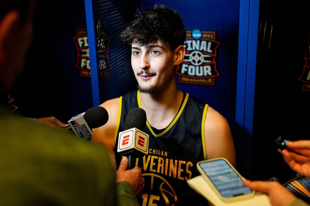 Michigan center Aday Mara (15) is being interviewed in the locker room at Lucas Oil Stadium in Indianapolis on Friday, April 3, 2026
