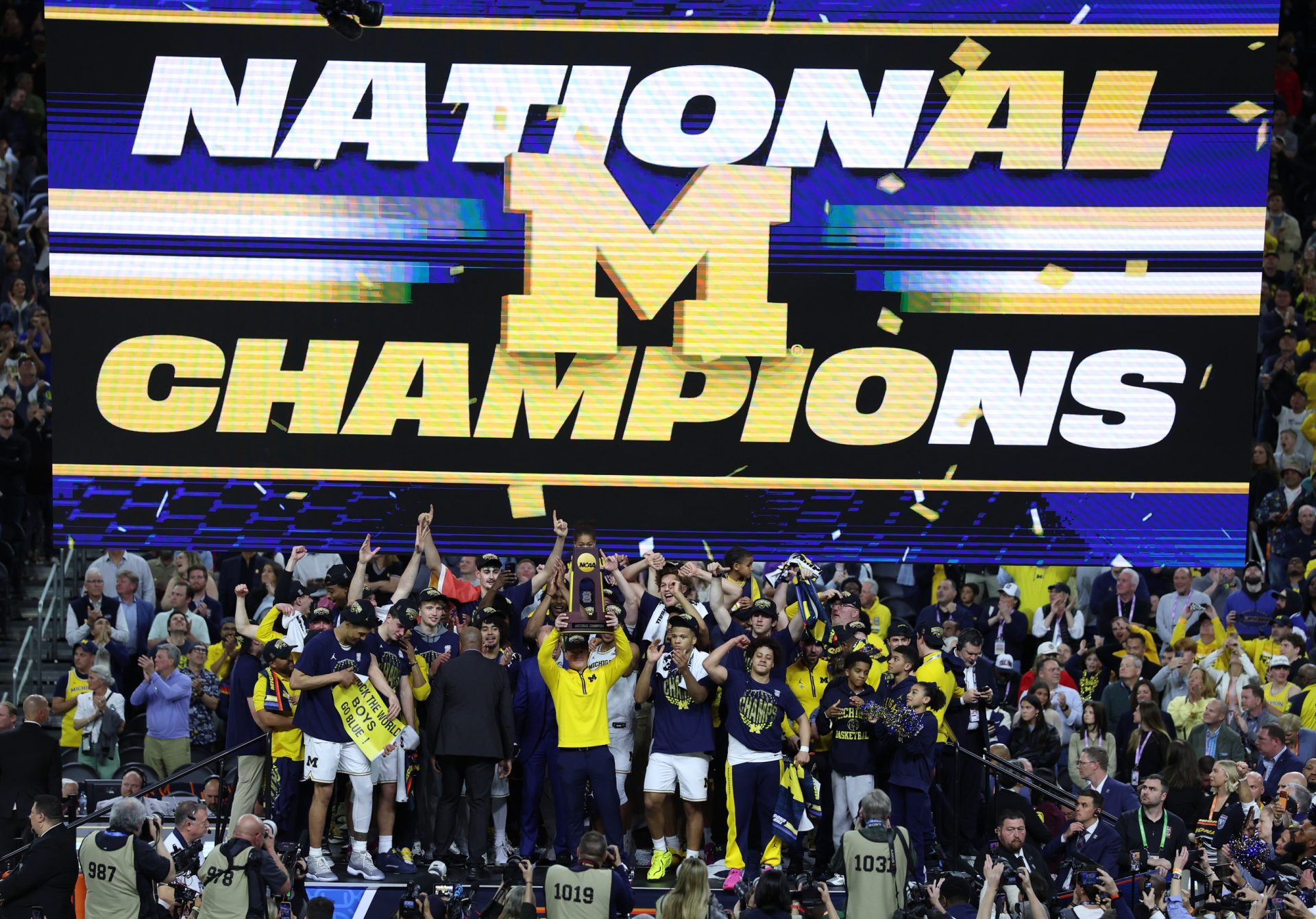 Apr 6, 2026; Indianapolis, IN, USA; Michigan Wolverines head coach Dusty May celebrates with the trophy after defeating the UConn Huskies in the national championship of the Final Four of the men's 2026 NCAA Tournament at Lucas Oil Stadium.