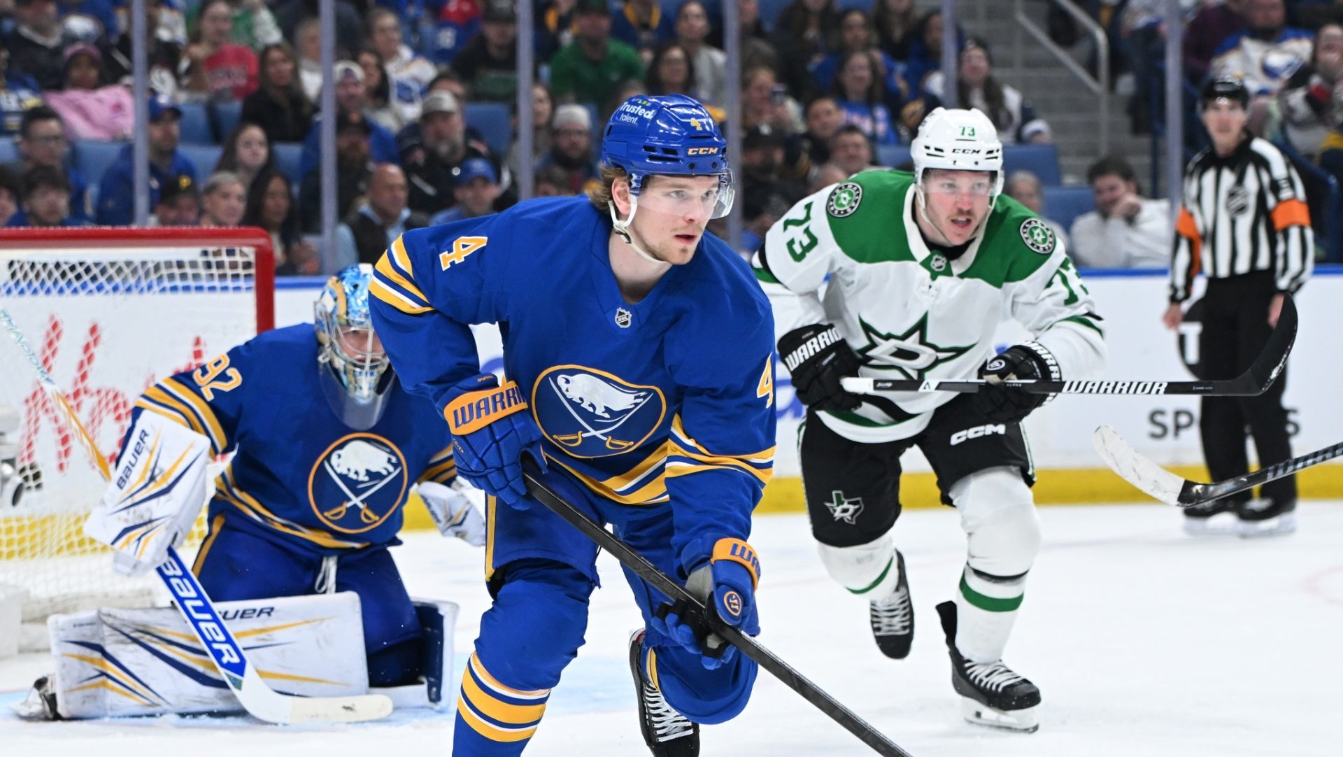 Apr 15, 2026; Buffalo, New York, USA; Buffalo Sabres defenseman Bowen Byram (4) clears the puck from the goal with Dallas Stars left wing Adam Erne (73) in pursuit in the third period at KeyBank Center.