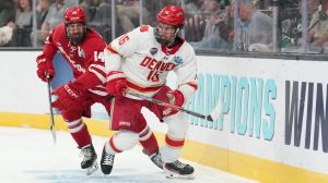 Apr 11, 2026; Las Vegas, Nevada, United States; Wisconsin Badgers defenseman Joe Palodichuk (14) and Denver Pioneers forward Kyle Chyzowski (16) battle for control of the puck during the second period in the championship game of the NCAA men's ice hockey Frozen Four at T-Mobile Arena