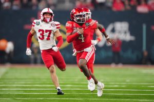 Dec 31, 2025; Las Vegas, NV, USA; Utah Utes quarterback Devon Dampier (4) carries the ball against Nebraska Cornhuskers defensive back Donovan Jones (37) in the second half during the SRS Distribution Las Vegas Bowl at Allegiant Stadium.