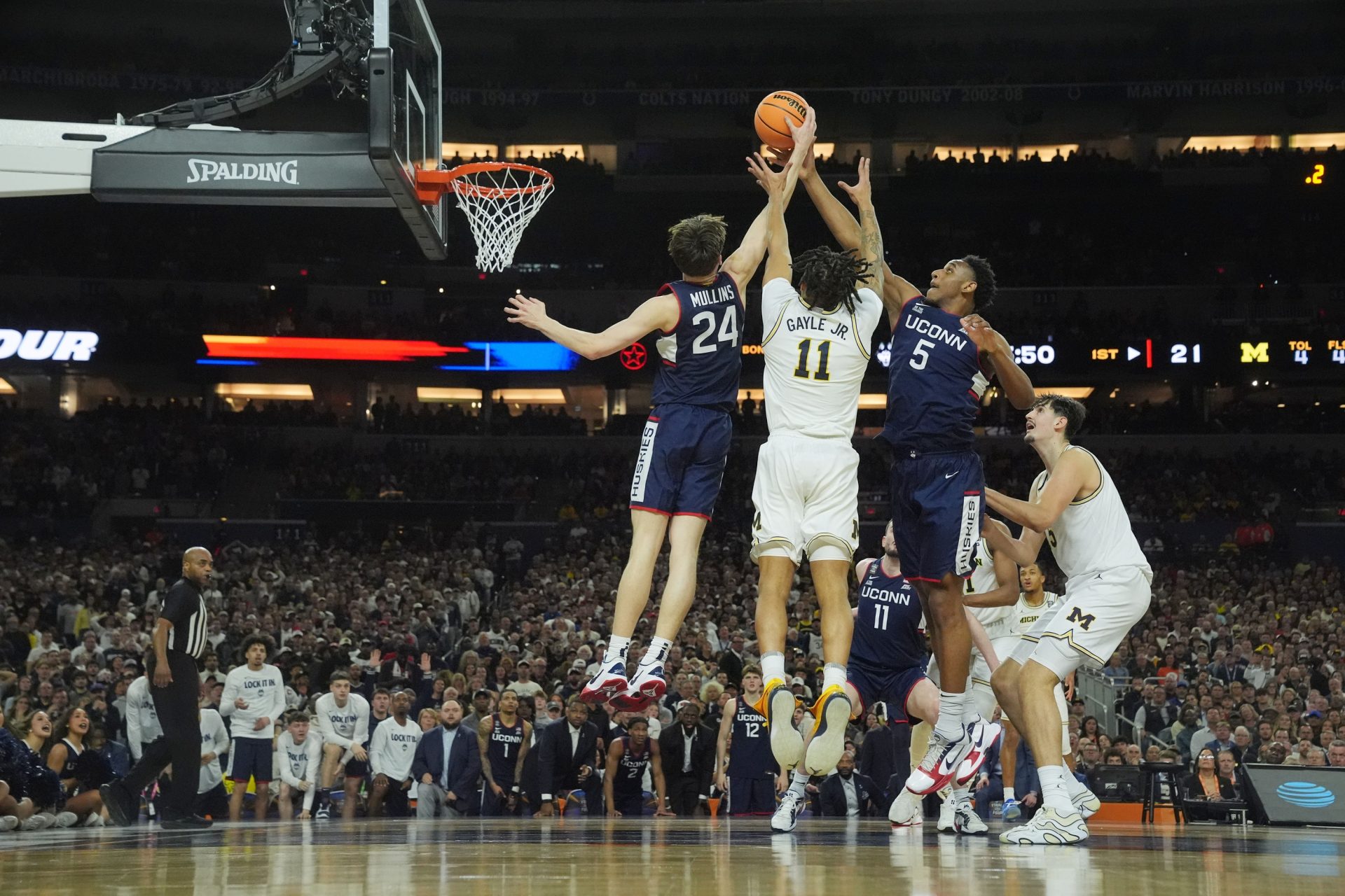 Apr 6, 2026; Indianapolis, IN, USA; Michigan Wolverines guard Roddy Gayle Jr. (11) goes up for a rebound against Connecticut Huskies guard Braylon Mullins (24) and Connecticut Huskies forward Tarris Reed Jr. (5) in the first half during the national championship of the Final Four of the men's 2026 NCAA Tournament at Lucas Oil Stadium.