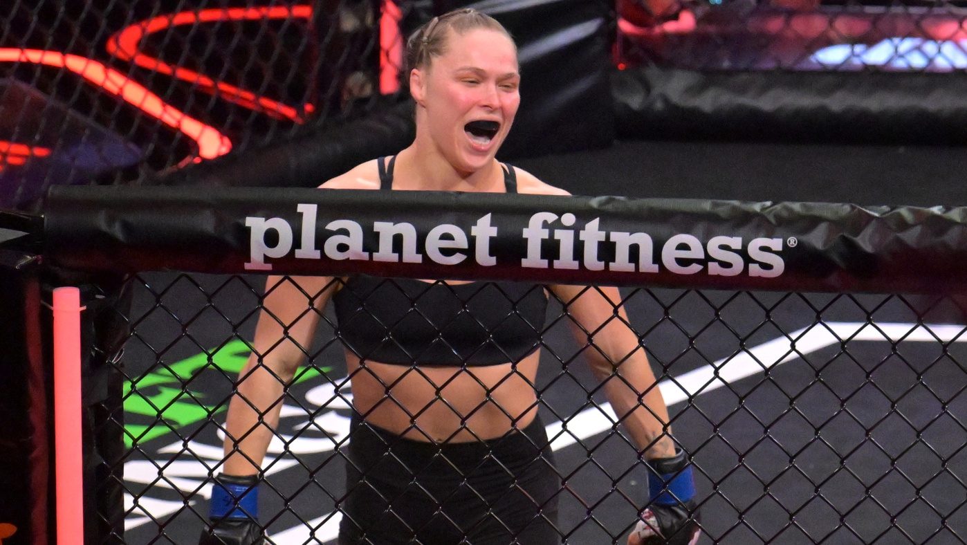 May 16, 2026; Los Angeles, California, USA; Ronda Rousey (blue gloves) celebrates defeating Gina Carano (red gloves) after a women's featherweight bout at Intuit Dome. Mandatory Credit: Jayne Kamin-Oncea-Imagn Images