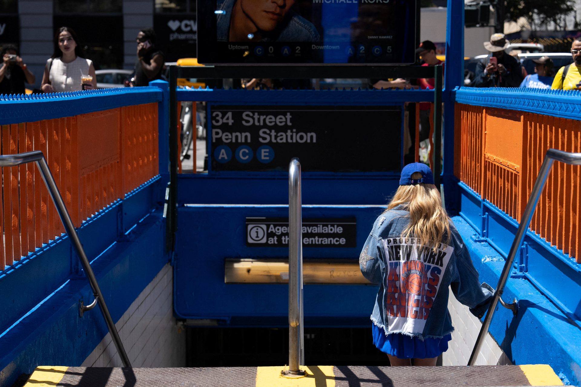 A New York Knicks fan walks at the 34th Street Penn Station subway entrance after the Metropolitan Transit Authority (MTA) painted it in orange and blue in honour of the hometown team's first championship finals in 27 years, in New York City, U.S., June 2, 2026.