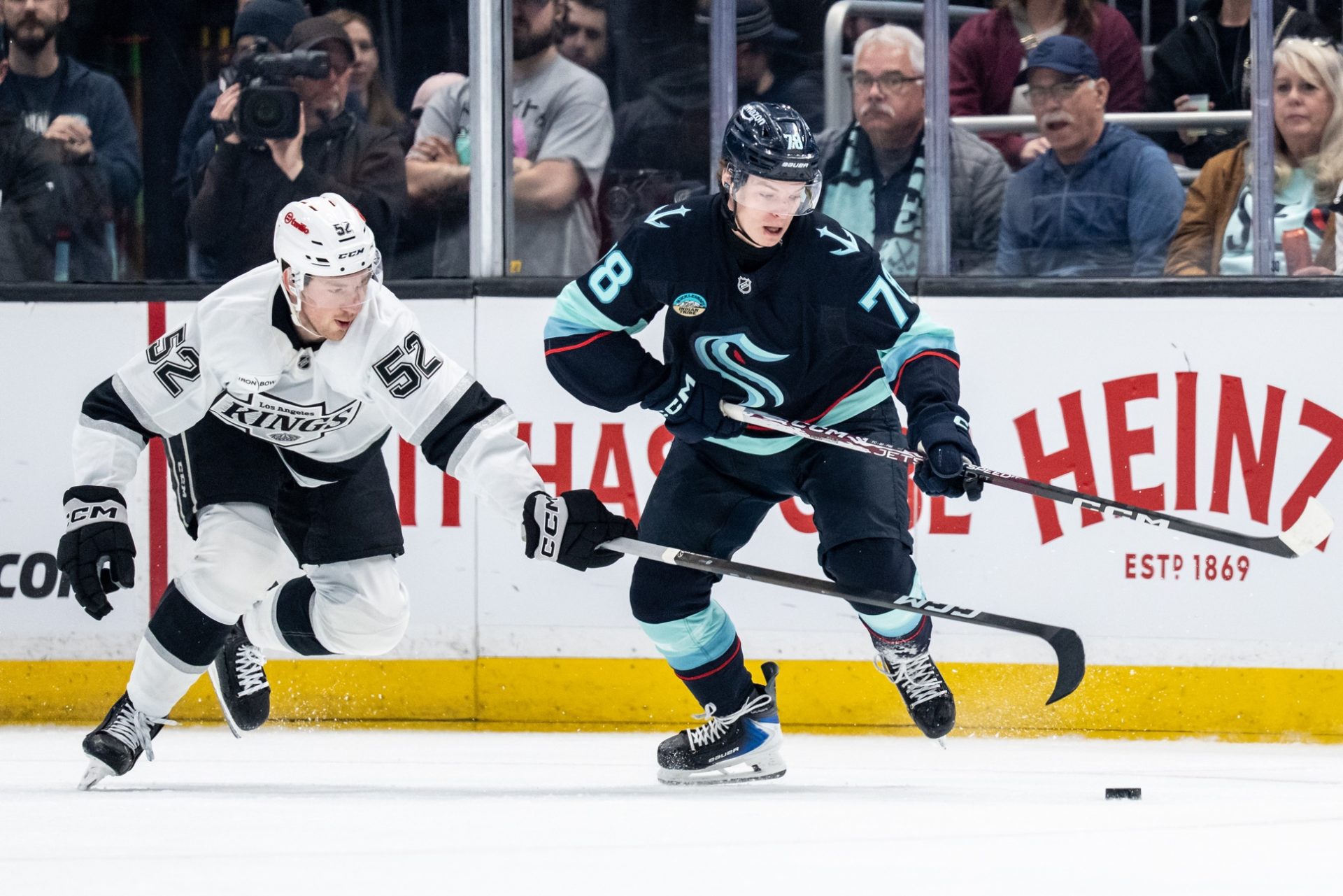 Apr 13, 2026; Seattle, Washington, USA; Seattle Kraken forward Oscar Fisker Molgaard (78) and Los Angeles Kings forward Taylor Ward (52) battle for the puck during the first period at Climate Pledge Arena.