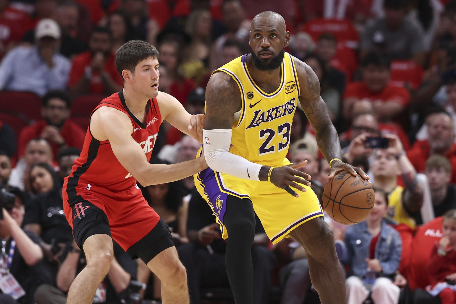 Apr 24, 2026; Houston, Texas, USA; Los Angeles Lakers forward LeBron James (23) controls the ball as Los Angeles Lakers guard Austin Reaves (15) defends during the first quarter during game three of the first round of the 2026 NBA Playoffs at Toyota Center.