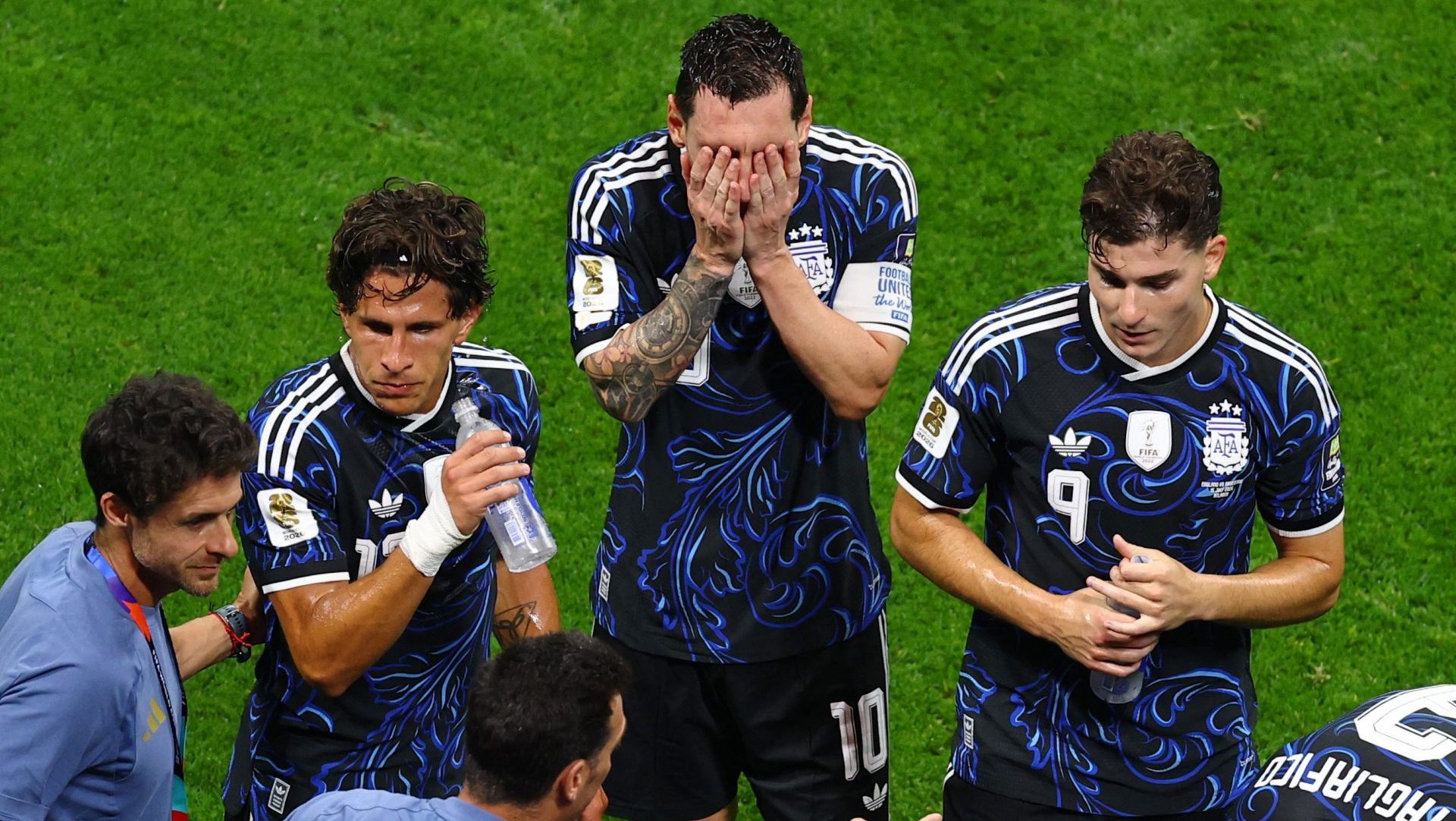 Soccer Football - FIFA World Cup 2026 - Semi Final - England v Argentina - Atlanta Stadium, Atlanta, Georgia, U.S. - July 15, 2026 Argentina's Lionel Messi wipes his face as coach Lionel Scaloni gives instructions to his players during a hydration break