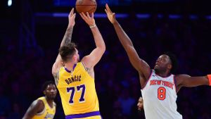Mar 6, 2025; Los Angeles, California, USA; Los Angeles Lakers guard Luka Doncic (77) shoots against New York Knicks forward OG Anunoby (8) during the first half at Crypto.com Arena. Mandatory Credit: Gary A. Vasquez-Imagn Images