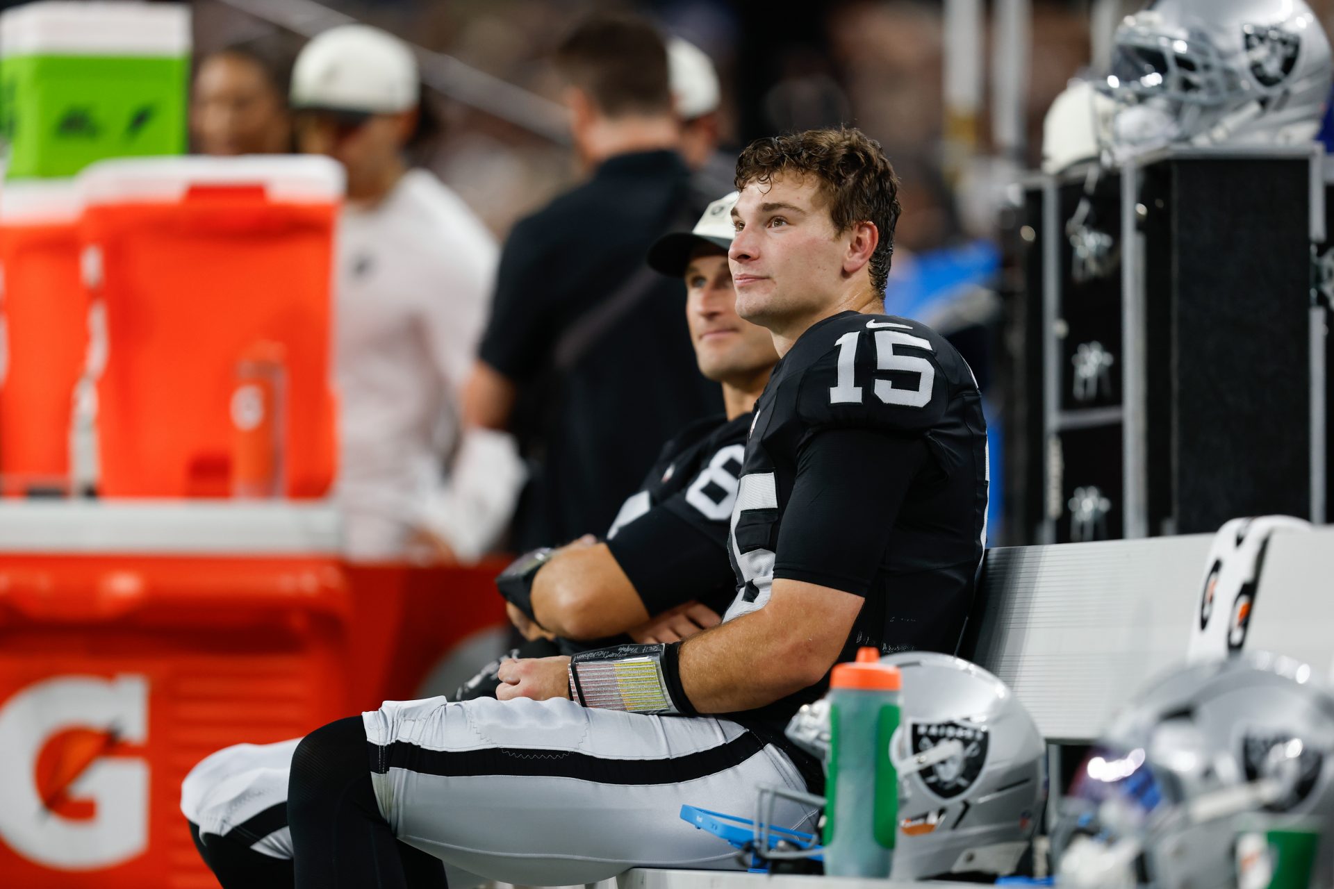 Aug 13, 2026; Paradise, Nevada, USA; Las Vegas Raiders quarterbacks Fernando Mendoza (15) and Kirk Cousins (8) sit on the bench while watching the action on the field during the game against the Arizona Cardinals at Allegiant Stadium.