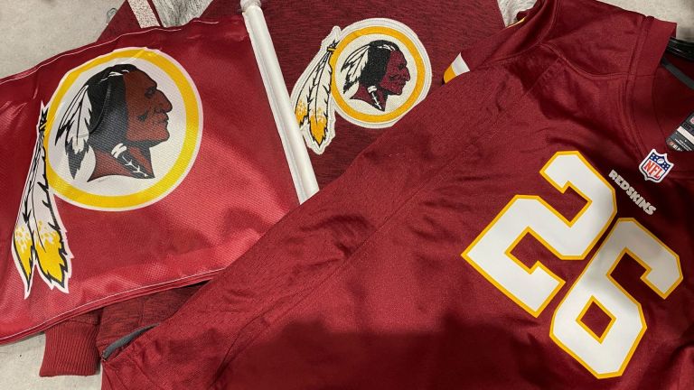 Washington Redskins football shirts and a team flag on sale at a sporting goods store in Bailey's Crossroads, Virginia, U.S., June 24, 2020. REUTERS/Kevin Lamarque