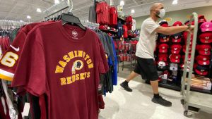 An employee passes Washington Redskins football shirts for sale at a sporting goods store in Bailey's Crossroads, Virginia, U.S., June 24, 2020. REUTERS/Kevin Lamarque