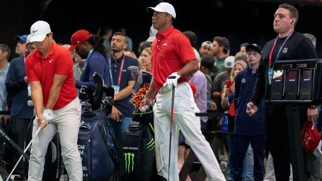 Tiger Woods of Jupiter Links GC stretches his left leg next to Tom Kim during warms up before match against the Los Angeles Golf Club who won the TGL finals at SoFi Center on March 24, 2026, in Palm Beach Gardens, Florida.