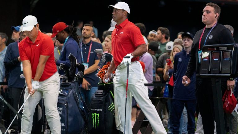 Tiger Woods of Jupiter Links GC stretches his left leg next to Tom Kim during warms up before match against the Los Angeles Golf Club who won the TGL finals at SoFi Center on March 24, 2026, in Palm Beach Gardens, Florida.