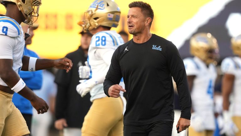 Sep 5, 2026; Berkeley, California, USA; UCLA Bruins head coach Bob Chesney (center) talks to UCLA Bruins linebacker Jalen Woods (left) before the game against the California Golden Bears at California Memorial Stadium. Mandatory Credit: Darren Yamashita-Imagn Images